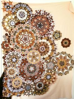 an art piece made out of many different types of buttons on a white wall hanging