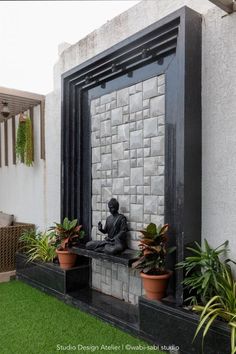 a statue sitting on top of a black bench next to potted plants in front of a building