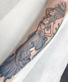 a woman with a mermaid tattoo on her arm