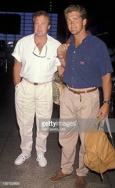 two men standing next to each other in an airport