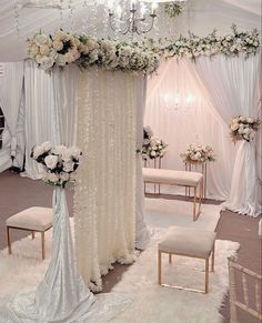 a white wedding setup with flowers and chandelier