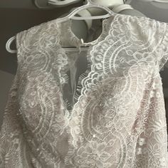 a white lace dress hanging on a hanger