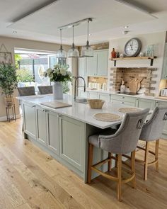 a kitchen with an island and chairs in it