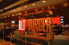 the restaurant is full of people and has a large sign that says, but burger