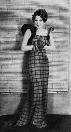 an old black and white photo of a woman in a dress with her hands on her hips