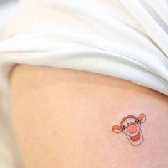 a person with a small tattoo on their stomach that has a monkey holding a carrot in it's mouth