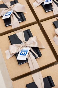 six boxes with brown and black wrapping ribbons tied around each one's ribbon bow