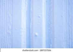 an image of snow on the side of a building with vertical lines and drops of water