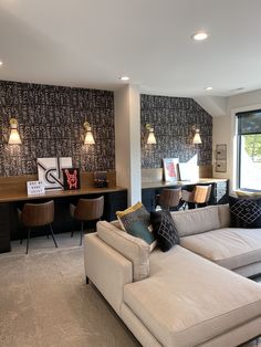 a living room filled with furniture next to a window covered in wallpaper and lamps