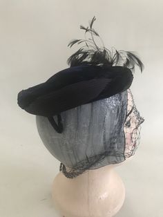 "Vintage 1940s 1950s blue velvet and satin hat with feathers, rhinestones and netting / veil. Sits on top of head. Velvet covered metal pieces at side back to secure to head. Circumfrence: 20\" Depth: 1.5\"" Evening Feather Hat Headpiece, Evening Feathered Hat Headpiece, Evening Hat With Feathers, Evening Costume Hat With Feathers, Vintage Feathered Headpieces For Vintage Events, Vintage Feather Headpieces For Vintage Events, Vintage Evening Fascinator With Feathers, Blue Vintage Fascinator For Party, Evening Fascinator With Feather Trim