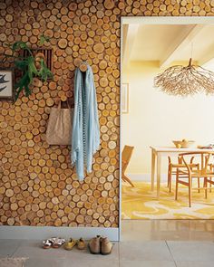 an open door leading to a dining room with wooden furniture and wall coverings on the walls