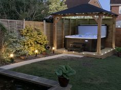 a gazebo with lights around it and a hot tub in the middle