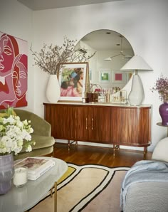 a living room filled with furniture and a large mirror on the wall above a coffee table