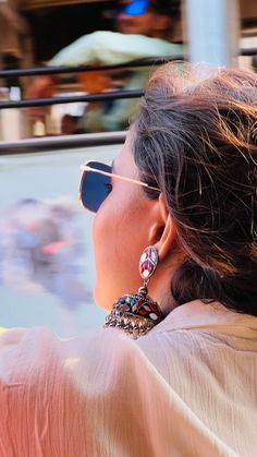 a woman wearing sunglasses is looking out the window