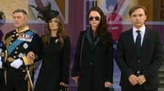 three people in suits and sunglasses standing next to each other