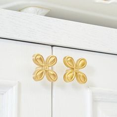 pair of gold flower earrings on white cabinet