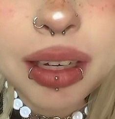 a woman with piercings on her nose and nose ring in front of her face