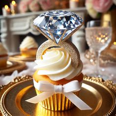 a cupcake with white frosting and a diamond on top, sitting on a gold plate