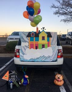 there is a car with balloons in the back and some decorations on the trunk,