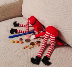 two red and white striped socks laying on top of a bed next to an empty toothbrush