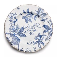 a blue and white plate with floral designs on it's rim, against a white background