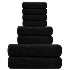 black towels stacked on top of each other in the shape of a pyramid against a white background