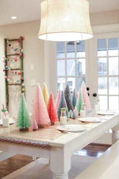 a table topped with lots of colorful christmas trees