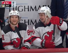 two hockey players sitting next to each other