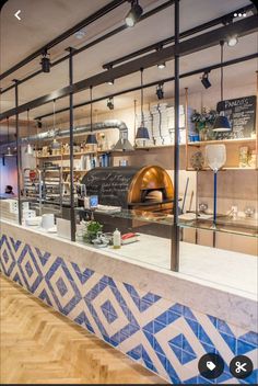 the interior of a restaurant with blue and white tiles on the wall, along with an oven