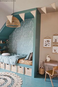 an attic bedroom with blue walls and wooden flooring is decorated in pastel tones