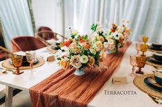 the table is set with orange and white flowers