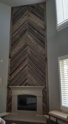 a living room with a fire place in the corner and wood paneling on the wall