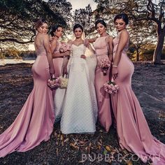 the bride and her bridesmaids pose for a photo in front of some trees