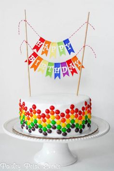 a birthday cake decorated with rainbow colored candies