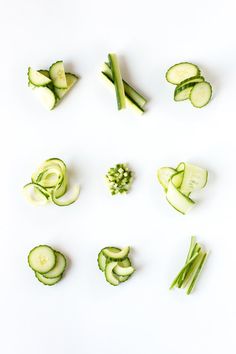 cucumbers and other vegetables cut up on a white surface