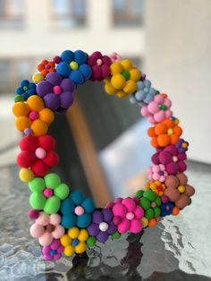 a colorful beaded mirror sitting on top of a table