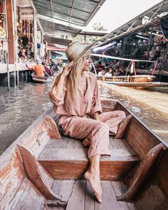 a woman sitting on the back of a boat