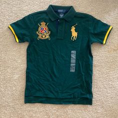 Green And Gold Polo By Ralph Lauren Polo Shirt. Army Green Polo Shirt With Gold Detailing And Patches. Size 7 Kids, Brand New With Tags. Green Short Sleeve School Shirt, Green Short Sleeve Shirt For School, Green Fitted Tops For School, Fitted Green Tops For School, Collar Shirt Outfits, Green And Yellow Outfit, Vintage Polos, Polo Aesthetic, Polo Shirt Outfit