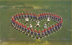 an aerial view of a marching band in the shape of a heart on a field