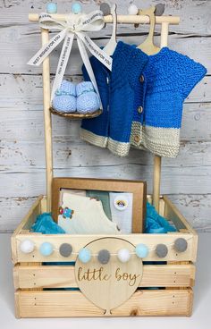 a wooden box with clothes hanging from it's sides and a sign that says little boy