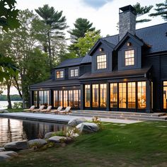 a large black house sitting next to a body of water