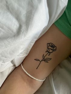 a woman's arm with a tattoo on it that has a single rose on it