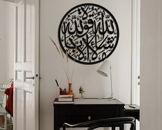 a room with a desk, chair and wall hanging on the wall in arabic writing