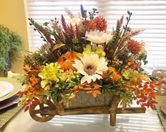 a wooden wheelbarrow filled with flowers on top of a table