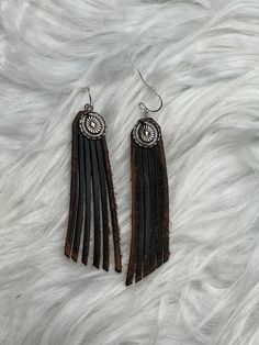 Silver Concho & Leather Fringe Earrings. These dangling earrings are a fun accessory for your trip to Nashville with the girls, the rodeo or just a fun night out at a country music concert. The conchos are silver metal. Choose from black or brown leather. Festival Concho Dangle Jewelry, Adjustable Concho Earrings For Festival, Western Style Concho Dangle Jewelry, Black Concho Jewelry For Rodeo, Black Concho Jewelry For Western-themed Events, Concho Drop Earrings, Western Style Dangle Earrings For Pierced Ears, Trendy Single Earring For Festivals, Nickel-free Western Style Earrings