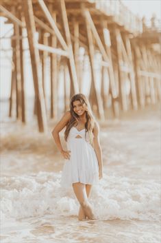 a beautiful young woman standing in the ocean