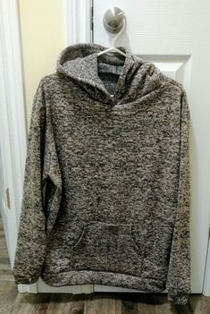 a gray hoodie is hanging on a door