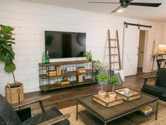 a living room filled with furniture and a flat screen tv mounted on a wall above a wooden coffee table