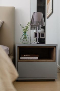 a nightstand with a lamp and a book on it