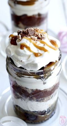 two desserts sitting on top of each other in glass jars with frosting and toppings